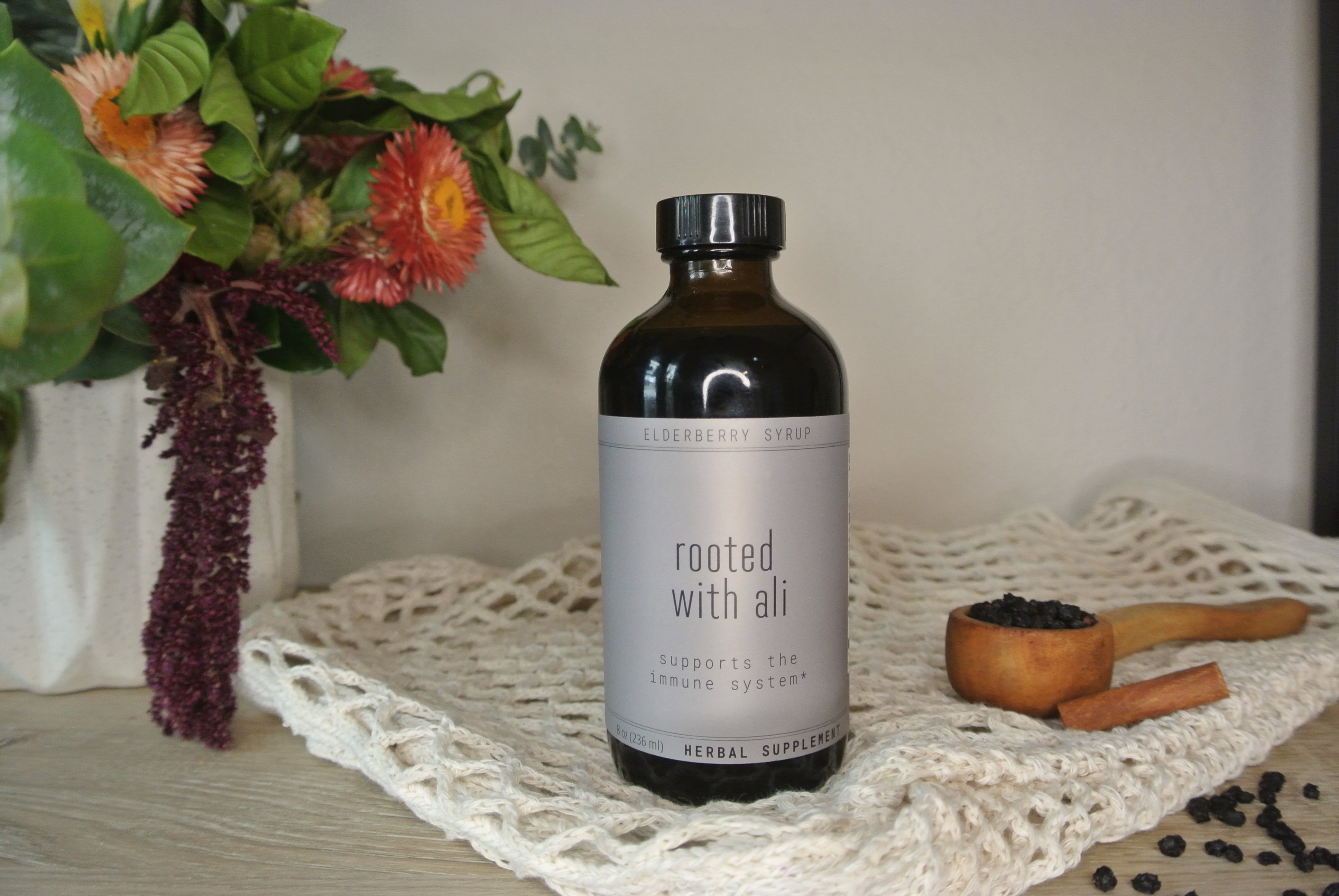 elderberry syrup on a table with flowers