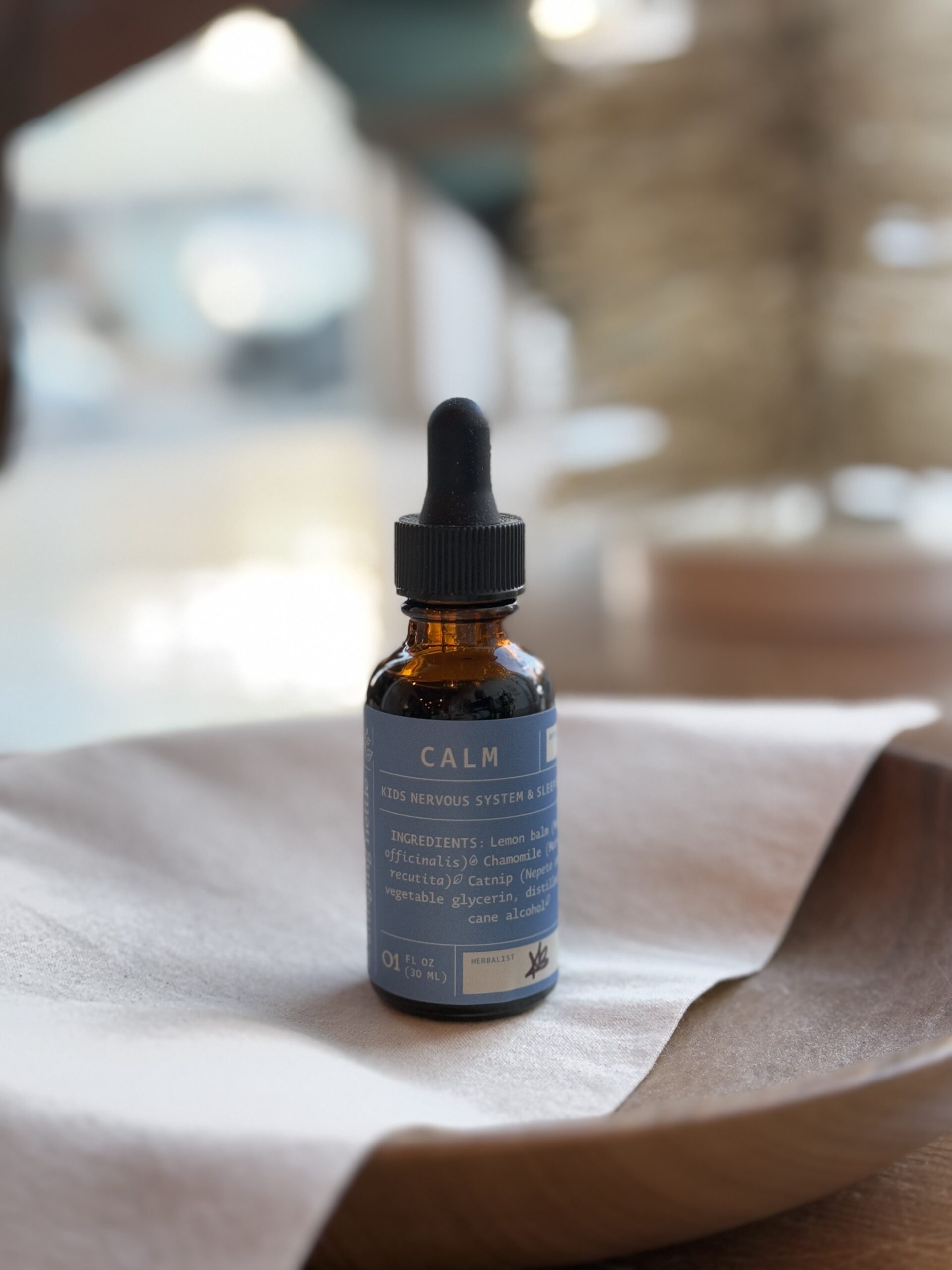 calm kids tincture on wooden bowl